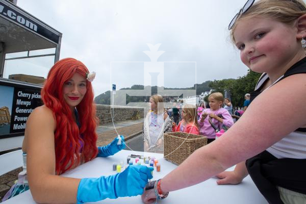 Picture by Karl Dorfner. 01-09-2024 - Havelet Regatta - Ella McKay and Aurora the Mermaid painting tattoos with glitter at the event