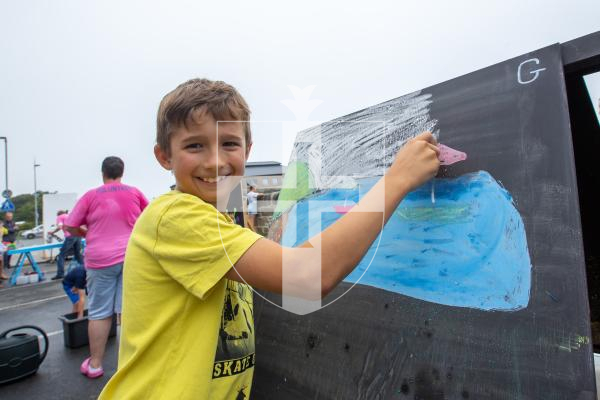 Picture by Karl Dorfner. 01-09-2024 - Havelet Regatta - Eddy Naftel (9) showing off his artwork at the chalk board section