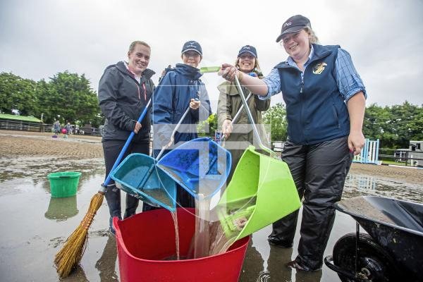 Picture by Peter Frankland. 24-08-24 Due to heavy rainfall in the early hours of this morning the Horse Of The Year  show has been delayed until the ground can be cleared of water. Bailing out by hand are L-R - Grace Edwards, Sam Rihoy, Sophie Dyer and Nicolle Maltwood.