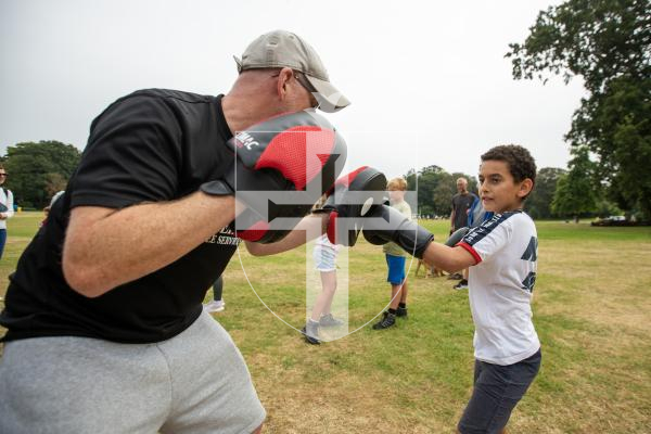 Picture by Karl Dorfner. 31-08-2024 - The Sauzmarez Park Sports Day Event - Ameer Saeed (11) and coach Dudley Boscher practicing on the pads at the boxing section of the event