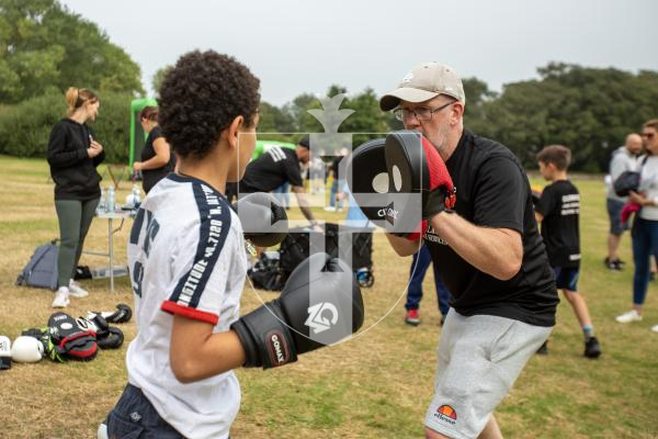 Picture by Karl Dorfner. 31-08-2024 - The Sauzmarez Park Sports Day Event - Ameer Saeed (11) and coach Dudley Boscher practicing on the pads at the boxing section of the event