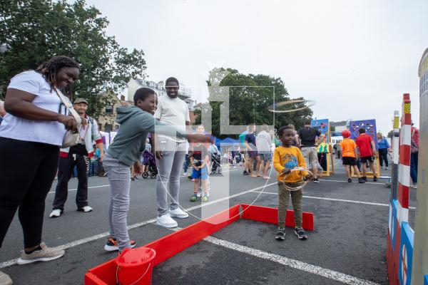 Picture by Karl Dorfner. 01-09-2024 - Havelet Regatta - Brothers Kashmar Pinnock  (9) and Kasane (4) with mum and dad Kasheka and Basane playing the hoopla game