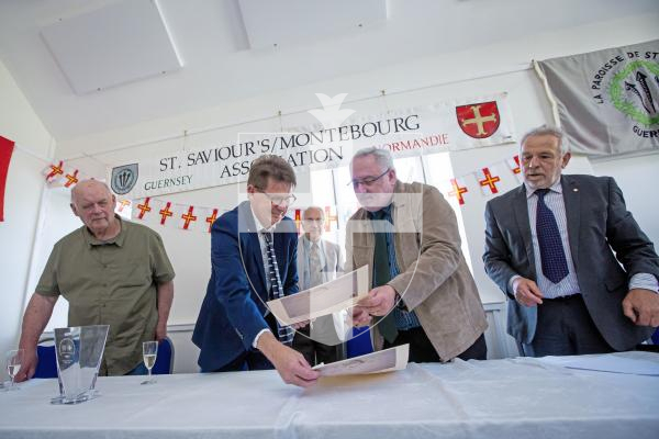 Picture by Peter Frankland. 13-09-24 St Saviours Community Centre. A ceremony was held to celebrate the 30th anniversary of the twinning of the parish with Montebourg. Jean-Paul Manquest (mayor of Montebourg) and Paul Connolly (senior constable St Saviours) swap documents to sign. Watching on are (left) Maurice Varin (president of the twinning committee - Montebourg), John Gillson (ctr) (Junior Constable) and Stuart Crisp (right) (President of the twinning committee, Guernsey).