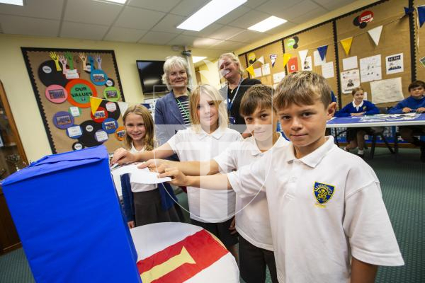 Picture by Sophie Rabey.  20-09-24.  La Houguette Primary School have been holding school council elections.  Polling was opened by special guest, Deputy Sue Aldwell today after a week of hustings for International Day of Democracy on the 15th.
Students L-R Arabella Yates (9), Evie Waldrom (9), Sebastian Crabtree (9) and Hugo Johnson (9) with Deputy Sue Aldwell and headteacher Claire Judd.