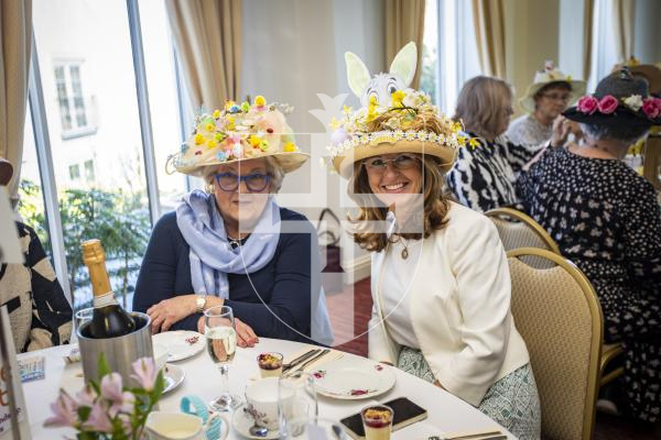 Picture by Sophie Rabey.  27-03-24.  Easter Bonnet Afternoon Tea Party at Les Cotils, raising money for the charity, Home-Start.  Ladies wearing their handmade hats.  L-R Celia Howe and Esme Bishop.