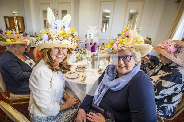 Picture by Sophie Rabey.  27-03-24.  Easter Bonnet Afternoon Tea Party at Les Cotils, raising money for the charity, Home-Start.  Ladies wearing their handmade hats.  L-R Esme Bishop and Celia Howe.