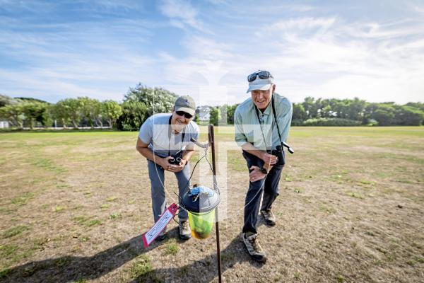 Picture by Sophie Rabey.  26-08-25.  The Asian Hornet team undertaking a 'tinsel tracking' technique (that involves attaching a long visible strip on a worker hornet to track it back to its nest) at La Mare De Carteret Playing Fields.  
L-R Nik Carre (Land Management & Asian Hornet Officer for Agriculture, Countryside & Land Management Services) and Francis Russell (Project Coordinator - Asian Hornet Strategy).
