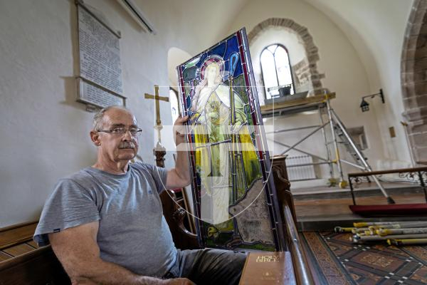 Picture by Peter Frankland. 27-08-25 A stained glass window at Forest Church has been removed, restored and is now being reinstalled in place. Peter Vivian of Guernsey Glass Craft was carrying out the work.