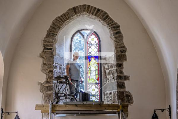 Picture by Peter Frankland. 27-08-25 A stained glass window at Forest Church has been removed, restored and is now being reinstalled in place. Peter Vivian of Guernsey Glass Craft was carrying out the work.