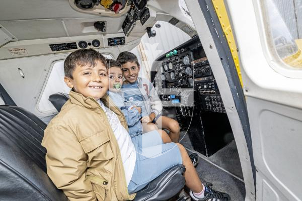 Picture by Sophie Rabey.  31-08-25.  Wings and Wheels event at Guernsey Areo Club.
L-R Teo Lela (6), Afonso Figueira (2) and Lourenlo Lela (9) enjoying sitting in the plane.