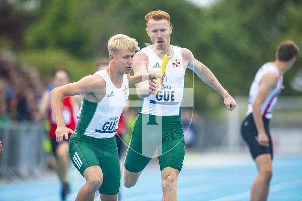 Picture By Peter Frankland. 14-07-23 Guernsey International Island Games 2023. Footes Lane - Athletics. Josh Duke takes over from Alastair Chalmers in the 4x400m relay.