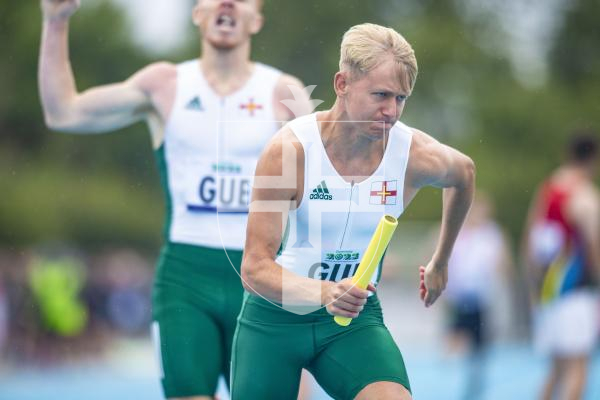 Picture By Peter Frankland. 14-07-23 Guernsey International Island Games 2023. Footes Lane - Athletics. Josh Duke takes over from Alastair Chalmers in the 4x400m relay.