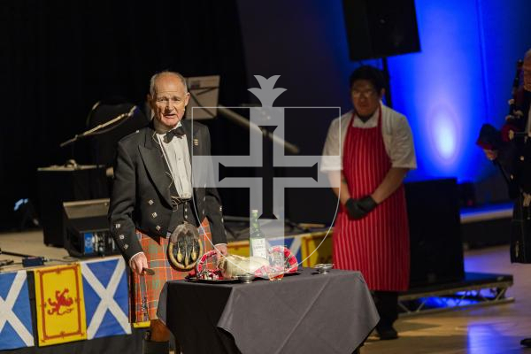 Picture by Sophie Rabey.  31-01-26.  Guernsey's Scottish Association held the Burns Night celebrations at Beau Sejour, sponsored by Titan Wealth.  The Haggis was piped in by Chris Bradshaw (piper) and carried by Mikee Bataller (chef).
Stuart Hardie (Past President of the GSA) doing the Address to the Haggis, followed by the drinking of whiskey.