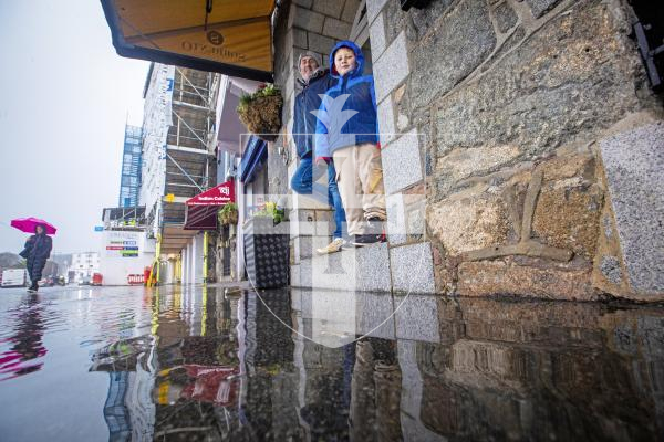 Picture by Peter Frankland. 13-02-24 A nearly 10m high tide in St. Peter Port caused a little flooding . Arthur Green, 7 and Ray Green came down to have a look.