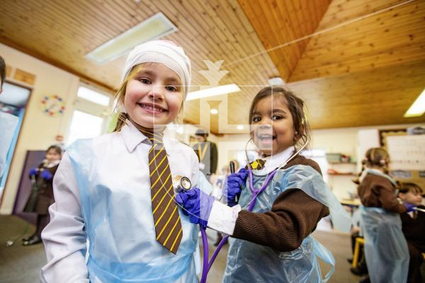 Picture by Sophie Rabey.  26-02-24.   ICU nurse, Tiffany Le Boutillier, visited reception children at St Mary & St Michael's school to talk about how she enjoys her career of being a nurse.  The children had a chance to try out some equipment.
L-R Lana Viera (aged 4) and Ella Pather-Jacob (aged 5) using a stethoscope.
