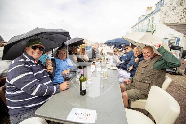 Picture by Sophie Rabey.  27-05-24.  Cobo Balcony Gig - ABBA Tribute.  People sheltering from the rain.