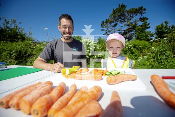 Picture by Peter Frankland. 05-06-24 Wild Wednesdays for early years children to discover nature activities at KGV. Alex Kosmas, Eat Well Lead at the Health Improvement Commission showing Sukie Mourant, 4 some healthy snacks.