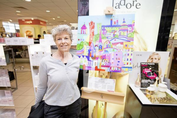 Pictured by Connor Rabey. 15/06/2024. 
'One Brushtroke' paintings on display in Creaseys in the High Street in town. Part of the Community Digital Art Project, created for and by the people of Guernsey.  
Liz Potter (President of Sarnia Arts and Crafts Club) next to the Townscape - based on a textile work by Jenny Mahy - brushstrokes were added through events over the past year.