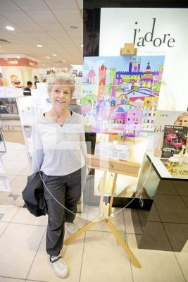 Pictured by Connor Rabey. 15/06/2024. 
'One Brushtroke' paintings on display in Creaseys in the High Street in town. Part of the Community Digital Art Project, created for and by the people of Guernsey.  
Liz Potter (President of Sarnia Arts and Crafts Club) next to the Townscape - based on a textile work by Jenny Mahy - brushstrokes were added through events over the past year.