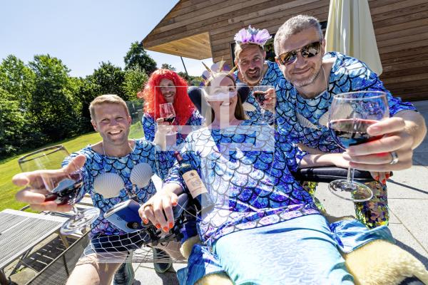 Picture by Peter Frankland. 03-07-25 Tom Falla and some of his friends are running the Medoc marathon (which involves drinking a glass of wine every mile) dressed as mermaids to raise money for MND charities. Tom's wife, Daisy, has MND. L-R - Dom Heaume, Tom Falla, Adam Dorey and James Draper. Pictured with Daisy Falla.