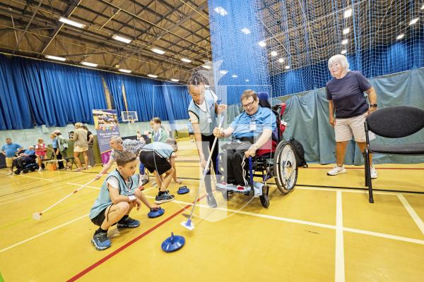 Picture by Sophie Rabey.  08-07-25.  A day of sports at Beau Sejour with students from St Martins Primary School and members of Guernsey Mobility, Lets Go!.  The children helped to assist those less able than them to compete in the challenges.
Olivia Elliot (aged 9) helping Lee Vaudin with a curling game.