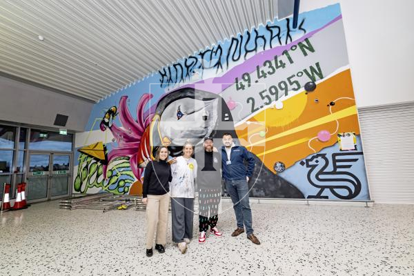 Picture by Sophie Rabey.  24-11-25.  The mural at Guernsey Airport, sponsored by Butterfield, has officially opened.  Tiffany Anna and Woodie have spent the last few weeks painting the scene of Guernsey related images.
L-R Claire Heaume (Marketing Manager at Butterfield), Tiffany Anna, Woodie and David Buddery (Guernsey Ports).