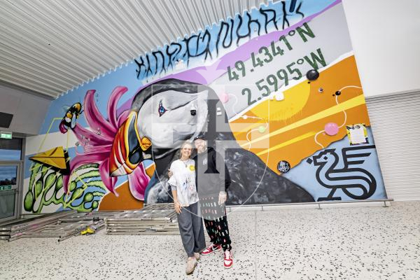 Picture by Sophie Rabey.  24-11-25.  The mural at Guernsey Airport, sponsored by Butterfield, has officially opened.  Tiffany Anna and Woodie have spent the last few weeks painting the scene of Guernsey related images.