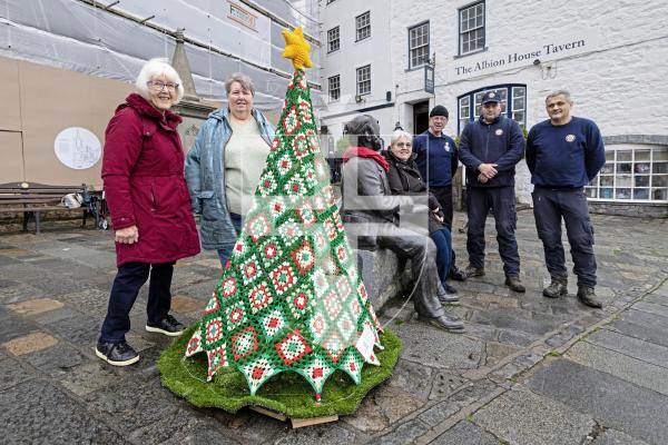 Picture by Peter Frankland. 08-12-25 A crocheted Christmas Tree made by the Women's Institute has been unveilled next to the Victor Hugo statue at the Town Church. L-R - Liz Walton and Rose Polli who helped with the knitting, Diane Mitchell, St Peter Port Constable, Chris Inder, Dillon Indge and Stuart Page are members of the St Peter Port Constables grounds team who put the frame and stand together.