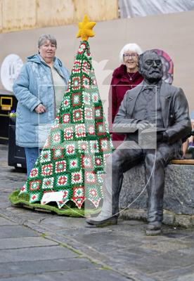 Picture by Peter Frankland. 08-12-25 A crocheted Christmas Tree made by the Women's Institute has been installed next to the Victor Hugo statue at the Town Church. L-R - Rose Polli and Liz Walton who were part of the crocheting team.