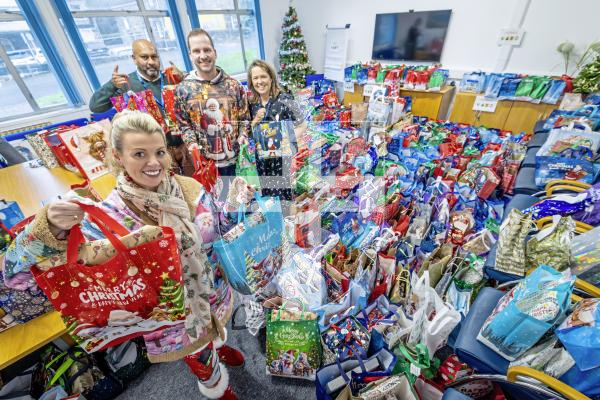 Picture by Peter Frankland. 17-12-25 Many bags of presents are now ready to be delivered community service users by the charity Gifts for the Elderly and Vunerable. L-R - Donna Patch, organiser and founder of Gifts for the Elderly and Vunerable, Collin Moodley, Social Care Team Co-ordinatior, Matthew Patch, helper and volunteer and Michelle MacMurray, Community Health Manager.