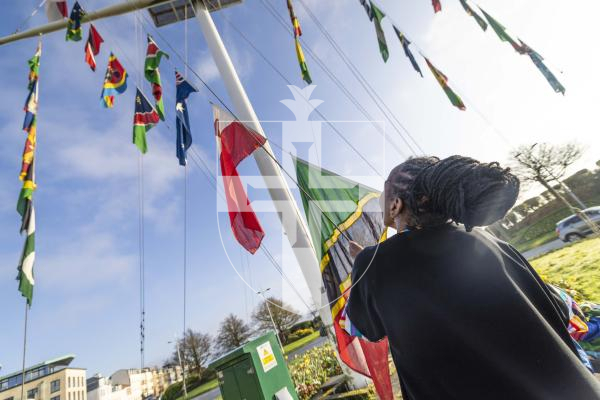 Picture by Peter Frankland. 09-03-26 Commonwealth Day flag raising at Weighbridge Roundabout. Ruth Mwaura raises some of the flags, including Kenya, where she is from.