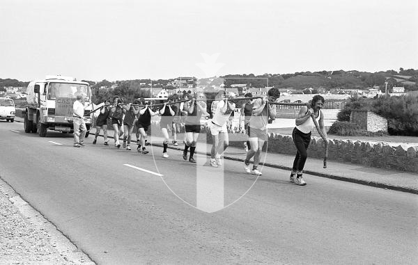 Picture by Guernsey Press.
Nostalgia Lookback feature.
31 Aug 1983. Neg number 1691/22/83.
20 fundraisers, regulars of the Vazon Bay Hotel and their friends, take the strain tugging a petrol tanker from Vazon to Pleinmont and back raising £850 in aid of Castel Hospital's Ward Four