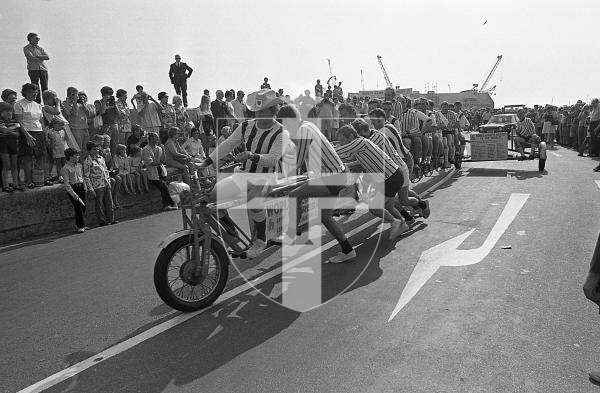 Picture by Guernsey Press.
Nostalgia Lookback feature.
27 Aug 1973. Neg number 3942/73.
22 policemen were seated on the world's longest bicycle measuring at 35 feet long. It's not the fastest machine the police have used, but it's the longest, and they needed a push before they could leave the White Rock.