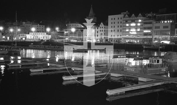 Picture by Guernsey Press.
Nostalgia Lookback feature.
5 Oct 1988. Neg number 2538/12/88.
Sea front lights reflect in an almost empty Victoria marina at night. Work had begun to make the pontoons more securely fitted.