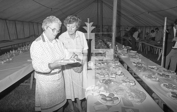 Picture by Guernsey Press. Nostalgia Lookback feature MONO. 
11th Aug 1983. Neg number 1566/15A/83.
Scones in the Guernsey section of cookery are judged by Mrs T. Bocock (left) and Mrs Betty Bishop at the South Show.