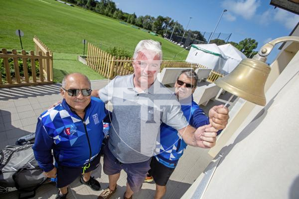 Picture by Peter Frankland. 20-08-24 The Mens T20 Cricket World Cup regional qualifiers  start tomorrow at KGV and Port Soif. Mark Latter, Tornament Director with L-R - Kostas Koronakis and Costas Vassilas of the Greek team. Ringing the bell to signal the start of the tournament.