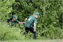 Guernsey's Eva Bourgaize helps Claire Davies out of the undergrowth after retreieving a lost ball